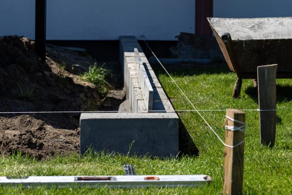 Marking out concrete block foundations for the terrace behind the house using string.